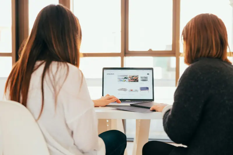 Two people at a laptop, seen from behind